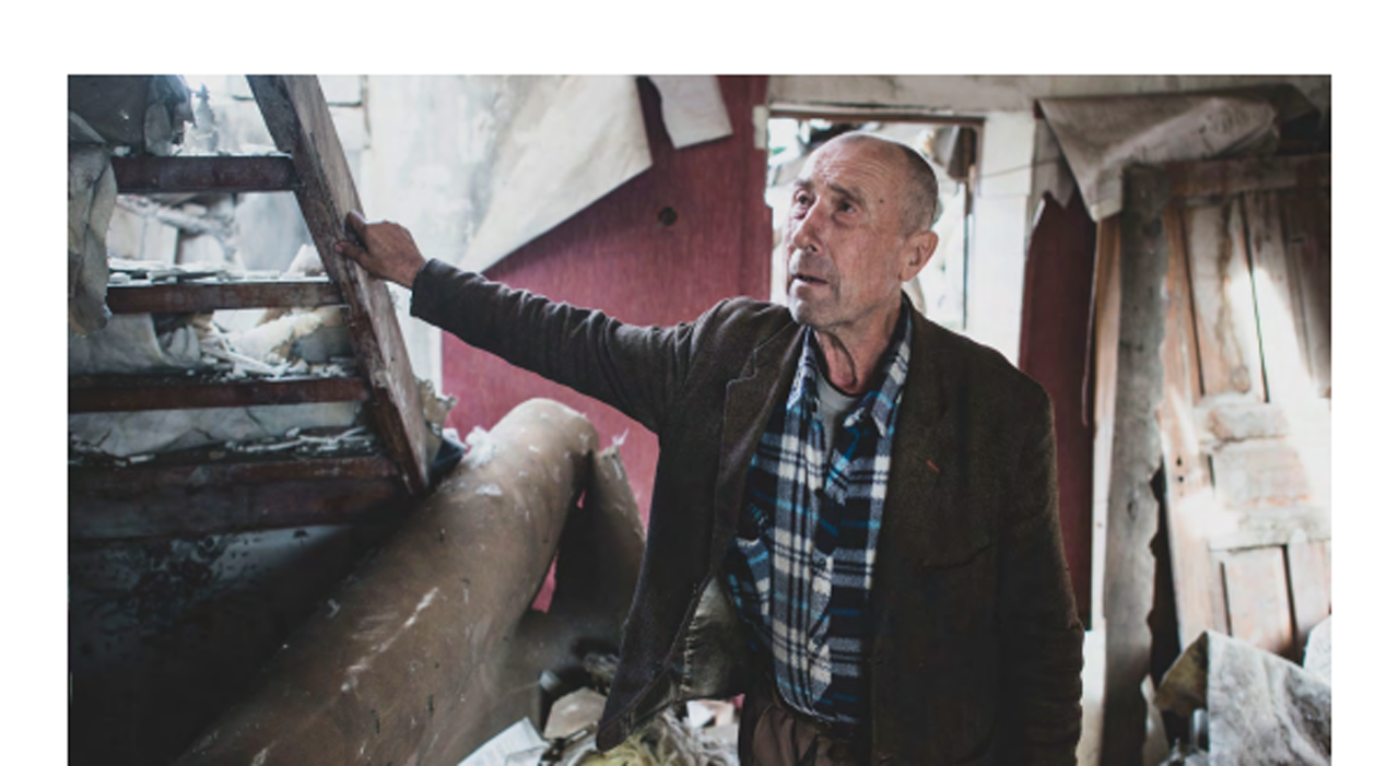 An old man showing the house he build for his children that was largely destroyed due to active hostilities.