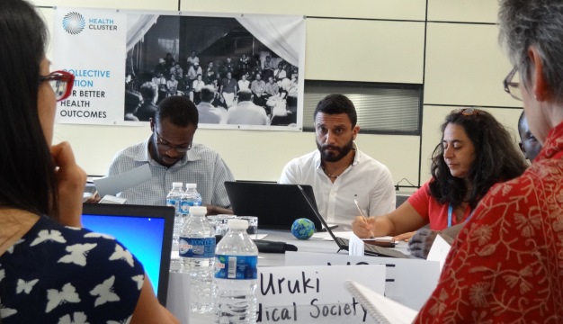 A simulated inter-cluster meeting discussing the fictitious state, Uruk. Participants, clockwise from left: Martins Livinus, Emanuele Bruni, Cecile Barbou des Courieres. Facilitators: Linda Doull (GHC) and Jolene Nakao (OFDA).