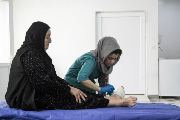 Quality-Iraq Healthcare worker supporting a patient's leg